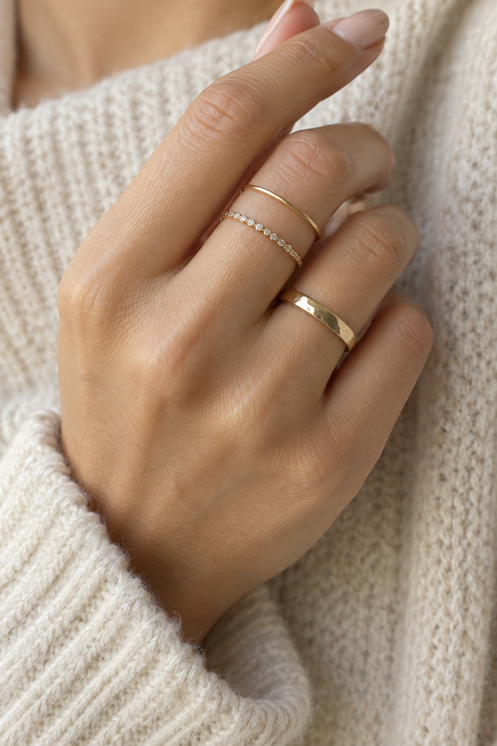 Mano con anillos midi delicados combinados con un anillo tradicional dorado