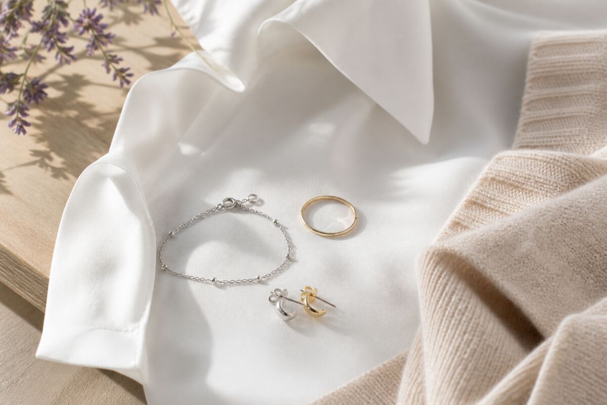 Pulsera, anillo y aros minimalistas junto a una camisa blanca