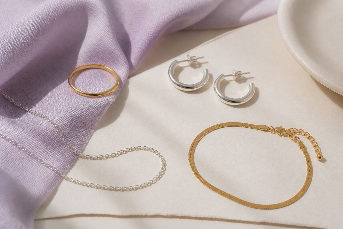 Joyas doradas y plateadas combinadas sobre tela lavanda