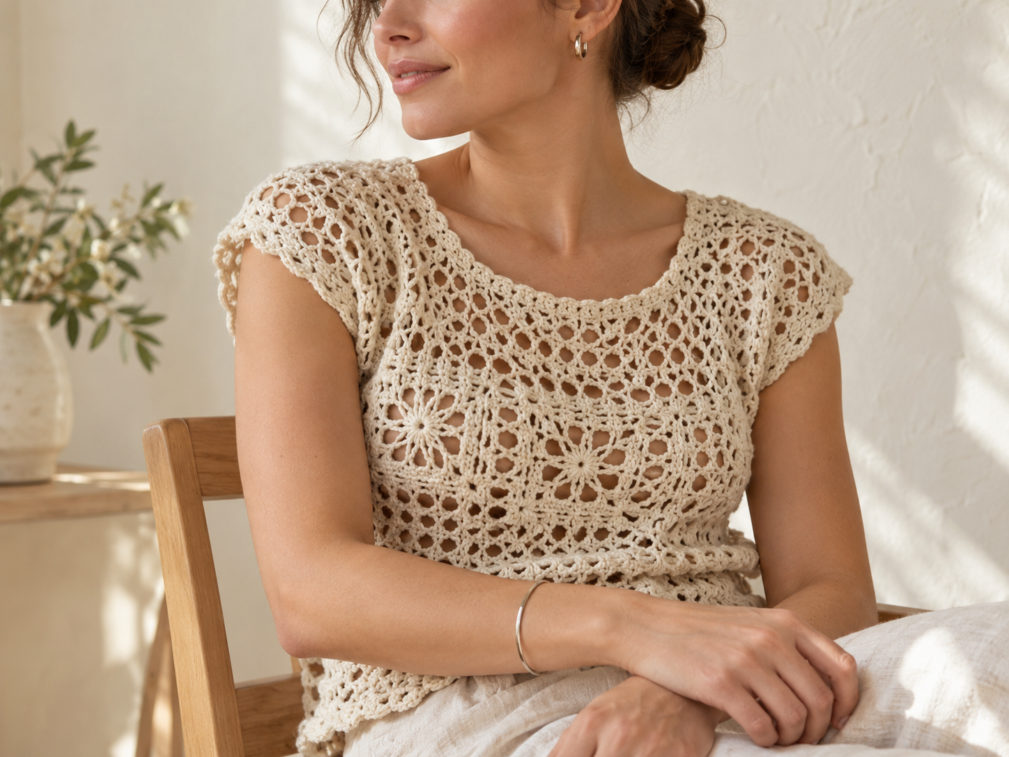 Prenda de crochet marfil combinada con joyas pequeñas y sencillas