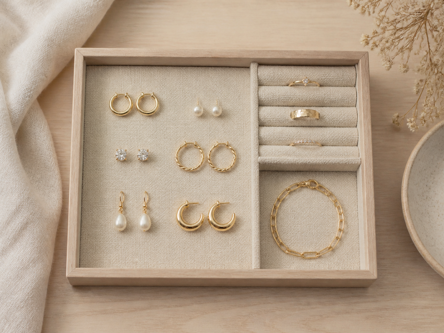 Bandeja ordenada con aros, anillos y pulsera para looks neutros