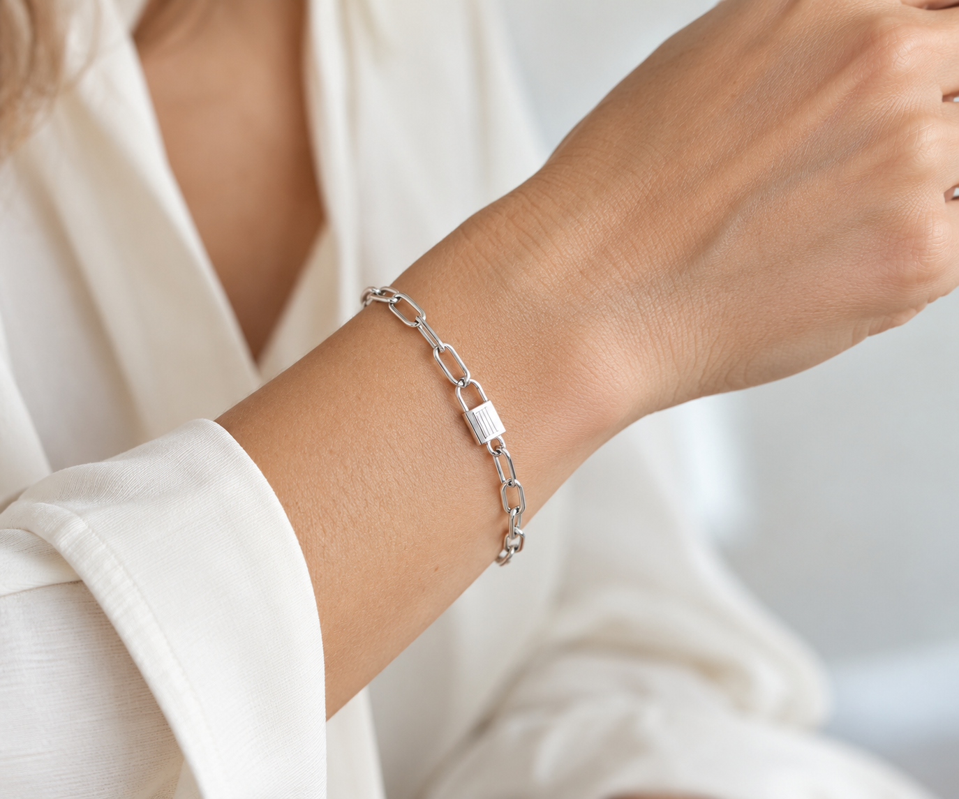 Pulsera plateada con eslabón central tipo candado en una muñeca