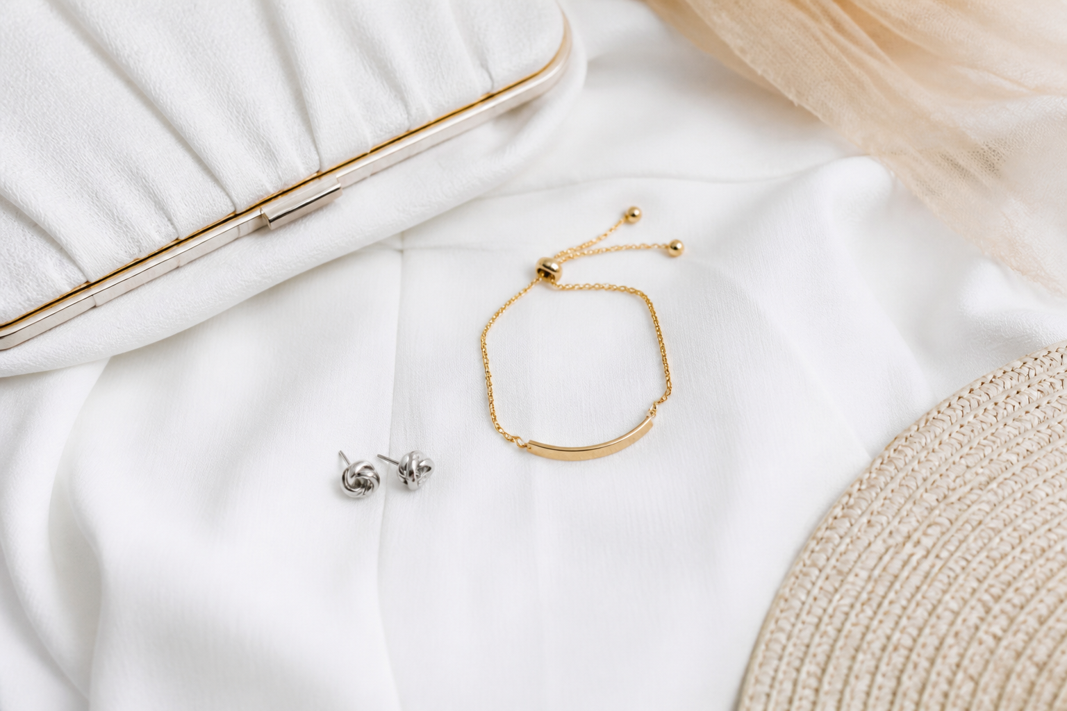 Pulsera dorada y aros plateados sobre vestido blanco