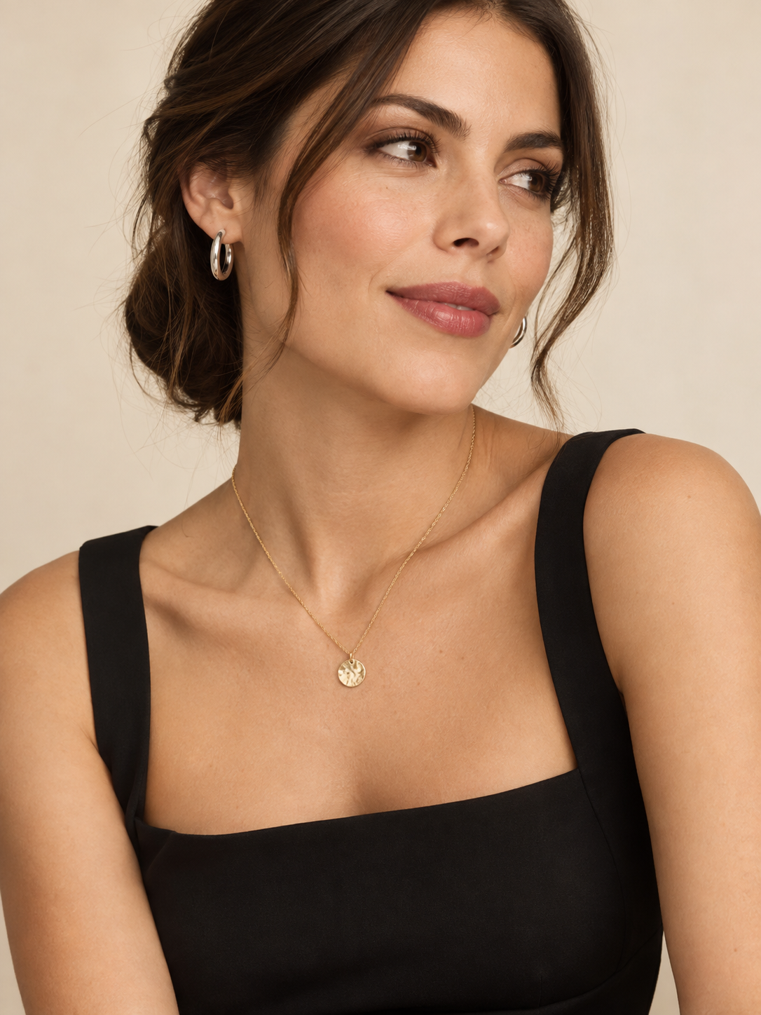 Aros plateados y collar dorado combinados con un vestido negro