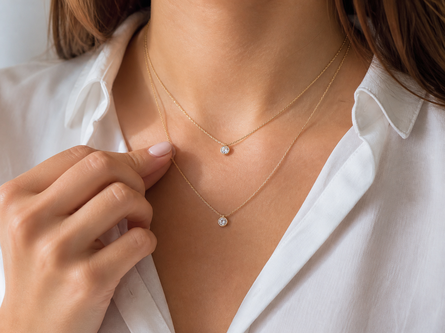 Dos collares de distinto largo comparados sobre una camisa blanca
