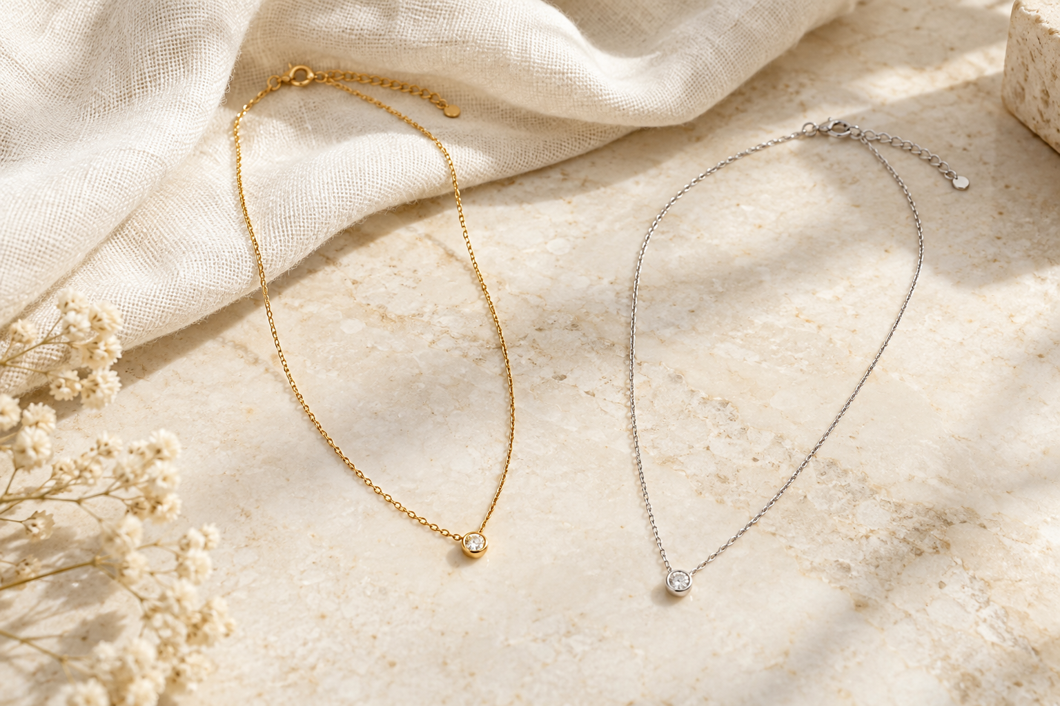 Collares punto de luz dorado y plateado extendidos sobre una superficie clara