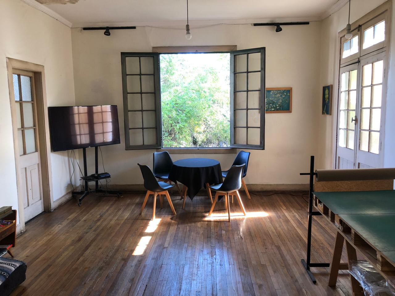 Interior del estudio, con mesa de reuniones y mesón de trabajo