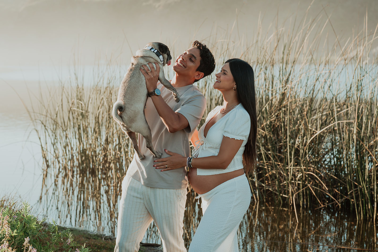 Pareja con su mascota en una sesión de fotos de embarazo al aire libre