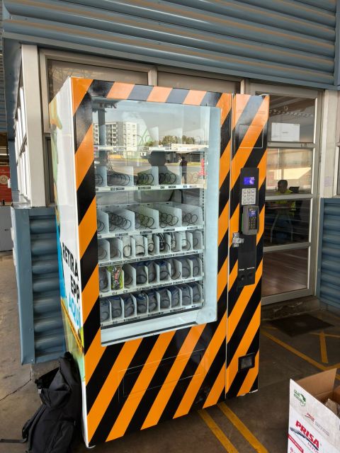 Máquina de EPP con chalecos reflectantes y guantes en un terminal de buses
