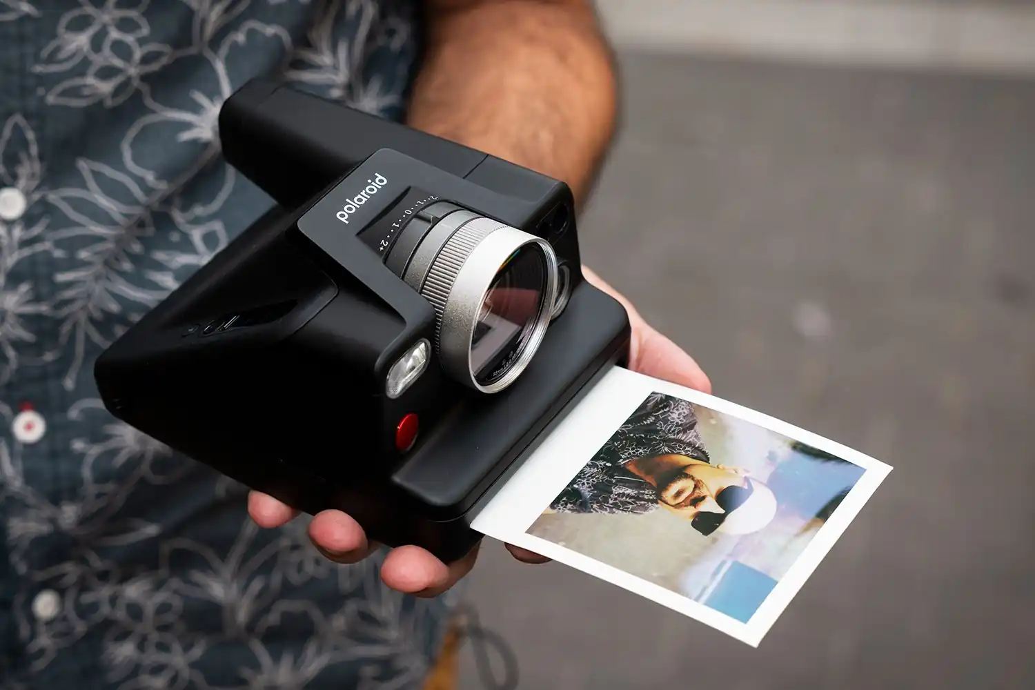 Cámara instantánea Polaroid imprimiendo una fotografía al instante, mostrando cómo funciona una cámara instantánea para capturar y obtener fotos físicas de forma inmediata